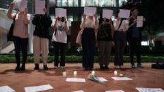 11月29日，在香港的大陸學生在香港大學為中國新冠「清零」政策受害者和烏魯木齊大火的受害者守夜時高舉著白紙。