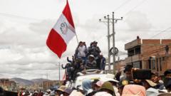 Manifestantes en la calle portando la bandera de Perú