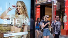 Peolep walking past a bus stop advertising for Chinese e-commerce fashion company Shein on 11 July 2026 in London.