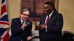 George Fouracres (as Sir Keir Starmer) and Hammed Animashaun (as David Lammy) in a sketch set in 10 Downing Street. 