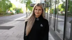 Dagy, 21, who's a student, stands in a street in Nottingham. She has blonde hair and is wearing a black top