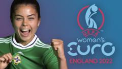 footballer joely andrews cheers while holding the front of her northern ireland national shirt next to the officialeufa women's euro logo