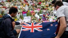 مواطنون يضعون علم نيوزيلندا بجوار الأزهار لإحياء ذكرى ضحايا إطلاق النار في كرايست تشيرش في عام 2019