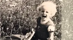 Maggie O'Farrell black and white photo of Maggie as a toddler 
blonde hair -- mouth open 
kneeling down on the ground 
rugged landscape of Ireland behind her