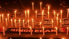 Lit candles are left as a tribute to the victims of the football disaster in Indonesia