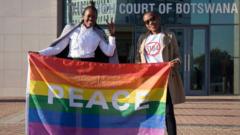 Activists pose with a rainbow flag as they celebrate outside Botswana High Court in Gaborone after the landmark ruling in June