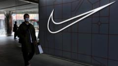 A man walks past a store of the sporting goods retailer Nike Inc at a shopping complex in Beijing.
