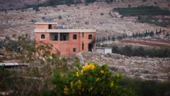 Edificio con humo y daños causados por la artillería.