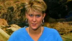 Annette Cowley in 1986. She has short hair and is wearing a blue top and hooped earrings.