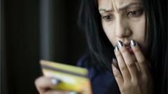 Женщина в ужасе смотрит на свою кредитку