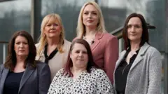 PA Media Five women stand outside the court building. They stand on stairs and, as a result, appear to be at different heights. Two are fair, three have black hair and all of their hair is about shoulder length. They are all fabulously dressed – four are wearing jackets (navy, cream, pink and grey) and one is wearing a black and white floral blouse.