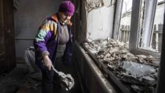 A woman cleans her damaged house after artillery fire from Donetsk region under the control of pro-Russian separatists in Donbas on February 23, 2022 in Mar'inka, Ukraine.