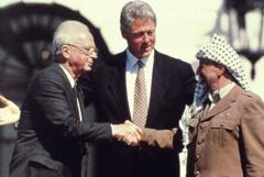 Dönemin ABD Başkanı Bill Clinton, İsrail Başbakanı Yitzhak Rabin ile Filistin lideri Yaser Arafat'ın Batı Şeria'nın büyük bölümünün Filistinlilerin kontrolüne geçmesini öngören anlaşmanın imzalanmasının ardından Beyaz Saray'ın bahçesinde el sıkışmalarını izliyor