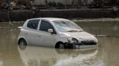 A car sits in water after the area was devastated by flooding in Mabi, Okayama prefecture on July 10, 2018.