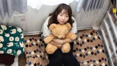 A woman with a teddy bear in a small flat