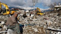 A woman sits amidst rubble and damages following an earthquake in Gaziantep, Turkey