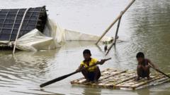 Indian villagers move to a safe place with the help of a boat in a flood-affected area in Assam