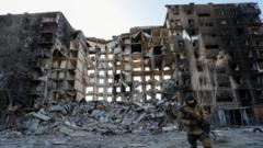 A service member of pro-Russian troops walks near an apartment building destroyed in the course of Ukraine-Russia conflict in the besieged southern port city of Mariupol