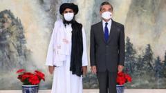 中國外交部長王毅（右）和阿富汗塔利班政治委員會負責人巴拉達爾（Mullah Abdul Ghani Baradar）