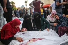 Mujeres lloran junto a cuerpos en el hospital Al Aqsa, en Deir Al Balah