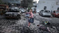 Una niña recolecta pertenencias cerca del hospital que fue atacado en Gaza.