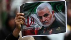 An Iranian holds up a picture of Qasem Soleimani in Tehran, Iran, on 4 January 2020