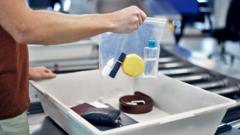 A person holds a bag of bottled liquids at airport security