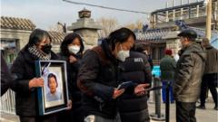 Relatives carry a picture frame of a loved at a crematorium in Beijing on December 20, 2022.