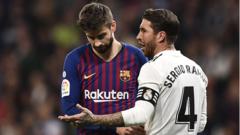 Barcelona centre-back Gerard Pique (left) dey follow Real Madrid counterpart Sergio Ramos (right) talk during an El Clasico match