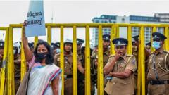 A lawyer holds a placard as policemen stand guard during a protest against the Prevention of Terrorism Act (PTA) law, which allows for the prolonged detention of suspects without trial, near the Presidential Secretariat in Colombo on October 10, 2022.