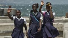 Schoolgirls wave while walking at Kingston harbour (pictured August 2012)