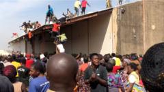 People gather around a warehouse in Bukuru, Nigeria, 24 October 2020