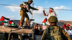 Homem brigam, um deles fortemente armado, em meio a bandeiras da Palestina e outros