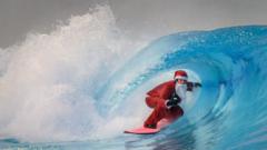 A surfer dressed as Santa Claus rides an artificial wave in acold water in the Alaia Bay surf wave pool in Sion, on 15 December 15, 2021.