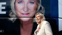 France's far-right party 'Rassemblement National' (RN) leader, Marine Le Pen candidate for the 2022 presidential election walks pas her portrait