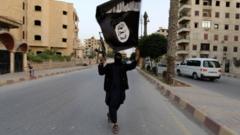 An IS militant waves a flag in Raqqa, Syria, in 2014