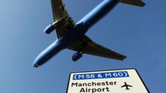 plane-flying-over-manchester-airport-sign