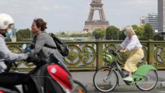 A woman wears a protective face mask while cycling across Pont Mirabeau bridge, near the Eiffel Tower