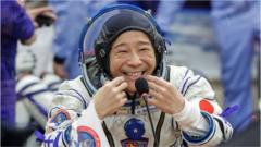 Japanese entrepreneur Yusaku Maezawa reacts as he speaks with his family after donning space suits shortly before the launch to the International Space Station (ISS) at the Baikonur Cosmodrome, Kazakhstan, 8 December 8, 2021.