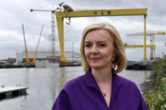 Liz Truss pictured with the Harland and Wolff cranes in Belfast in the background