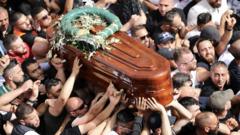 巴勒斯坦群众抬着半岛电视台遇害记者希琳·阿布·阿格莱（Shireen Abu Aqla）灵柩在耶路撒冷老城区游行（13/5/2022）