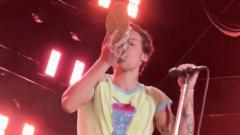 Harry Styles drinking from a shoe on stage