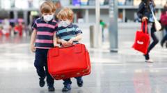 Two children with a suitcase in an airport