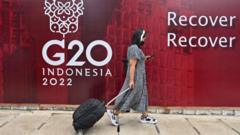 A woman walks past the G20 Indonesia 2022 logo in Jakarta