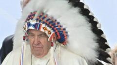 Pope Francis receives a War bonnet during a meeting with indigenous people for a silent prayer at the Maskacis cemetery, a town 100 kilometers south of Edmonton, Canada