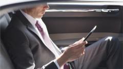 Homem de terno lendo tablet em carro de luxo