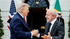 US President Donald Trump and Brazil President Luiz Inácio Lula da Silva greet each other at the White House in Washington on Thursday in this handout photo from the Brazilian government.