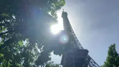 The Sun shining behind the Eiffel Tower