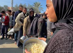 Lamees Mohammad Al Mizar'i is standing in line for rice