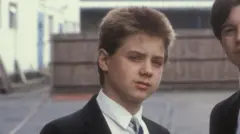 John Alford posing for a photo as Robbie Wright in school uniform.